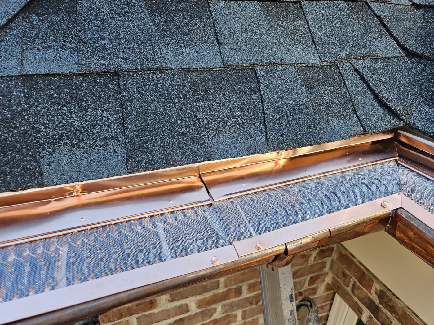 elite-home-services-nc-copper-gutter-guard-corner-joint-brick.webp