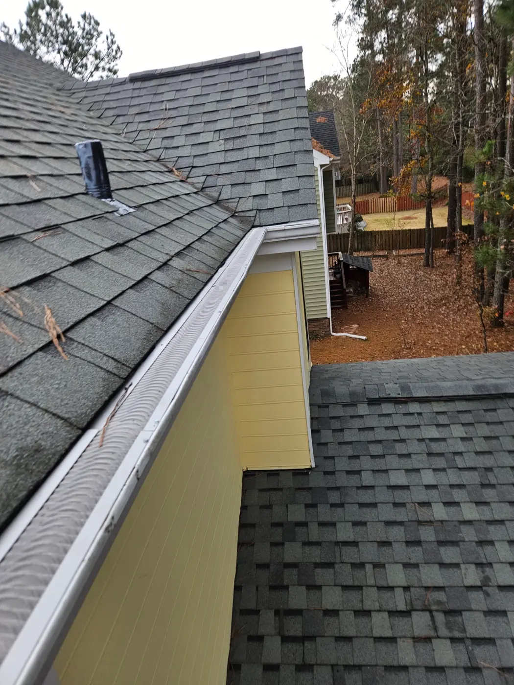 elite-home-services-nc-gutter-guard-roof-edge-yellow-siding.webp